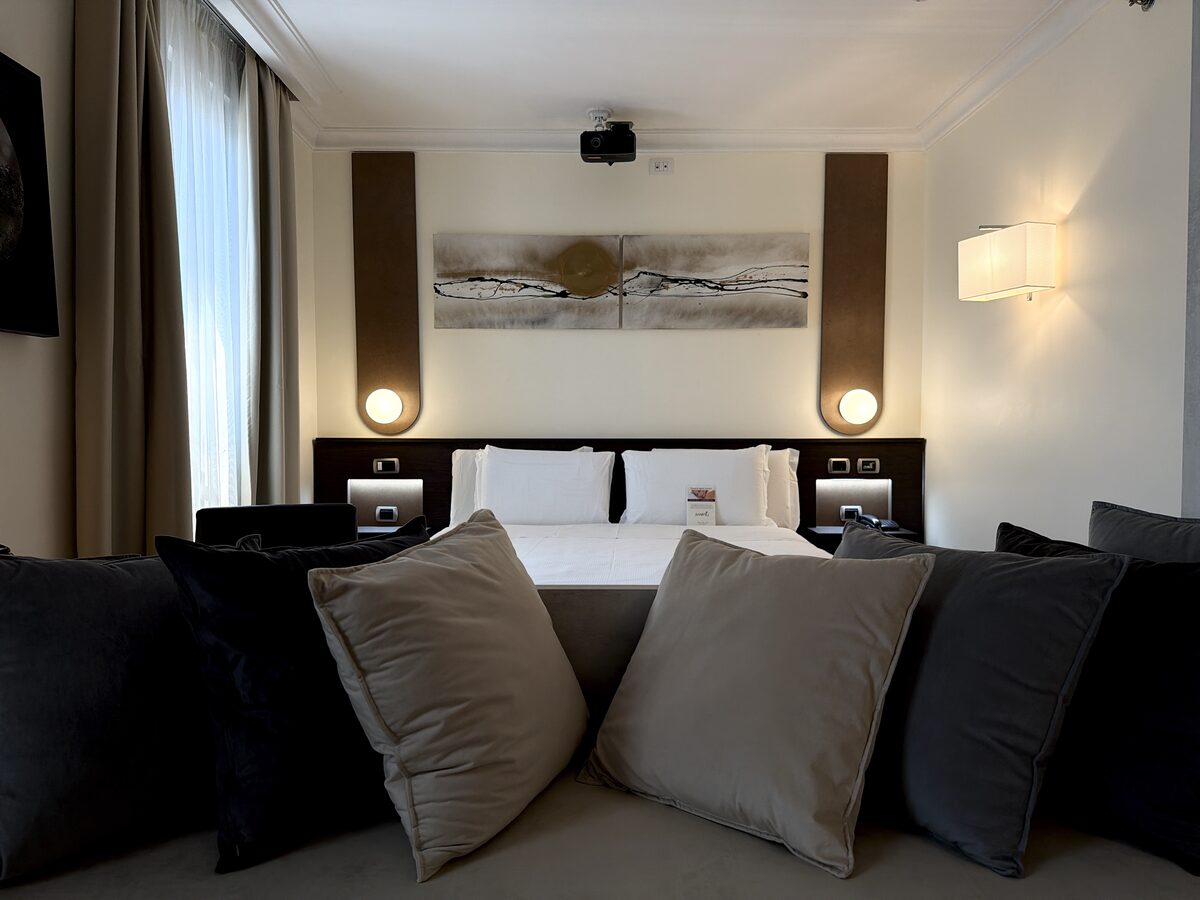 Letto king della Camera Cinema 210 con proiettore a soffitto — Trilussa Palace Hotel Roma